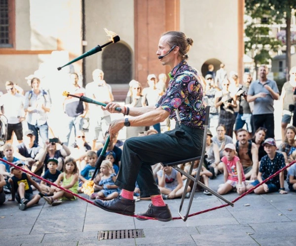 Fokussieren - Artist BOBBY GARDEN auf einem Stuhl sitzen auf einem Seil balancieren