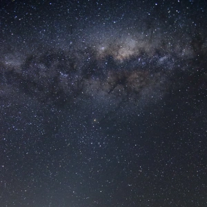 Ein voller Sternenhimmel über einer leeren Straße.