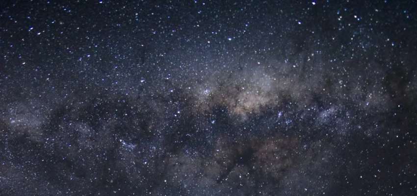 Ein voller Sternenhimmel über einer leeren Straße.