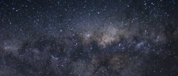 Ein voller Sternenhimmel über einer leeren Straße.