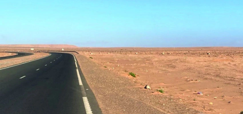 Eine leere Straße durch die Wüste.