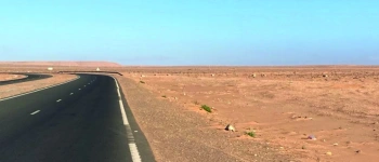 Eine leere Straße durch die Wüste.