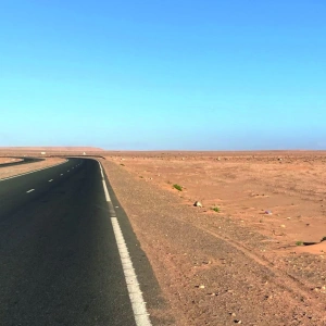 Eine leere Straße durch die Wüste.