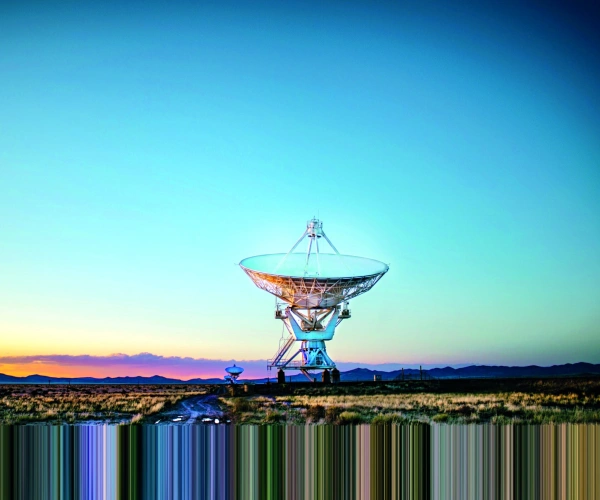 Eine Riesige Satellitenschüssel steht im Sonnenaufgang.