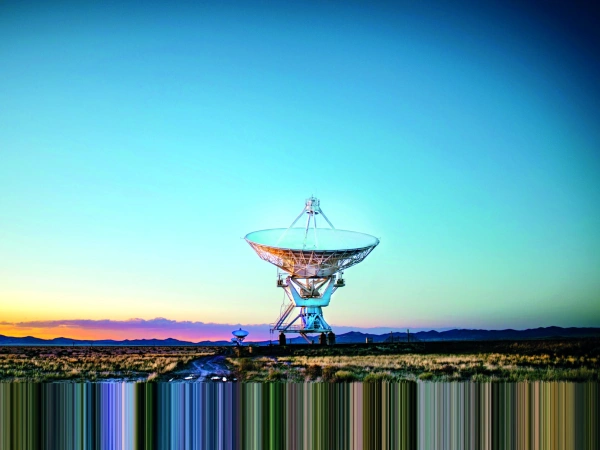 Eine Riesige Satellitenschüssel steht im Sonnenaufgang.