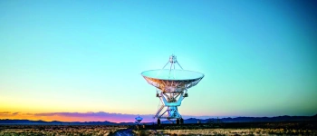 Eine Riesige Satellitenschüssel steht im Sonnenaufgang.