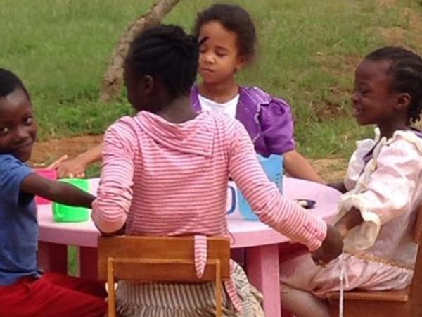 Eine Kindergruppe sitzt am Kaffeetisch.