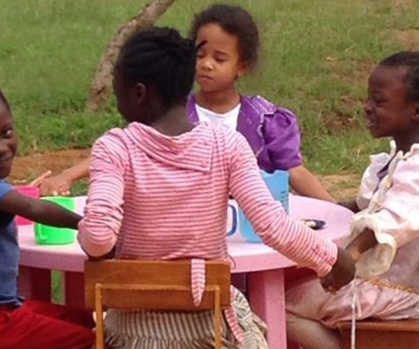 Eine Kindergruppe sitzt am Kaffeetisch.