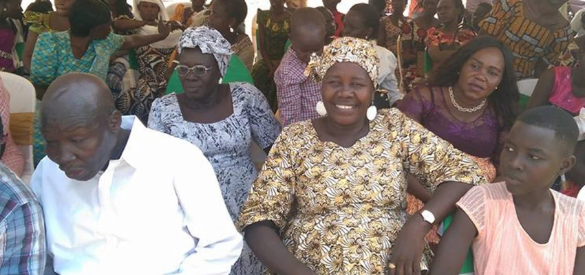 Eine Menschengruppe sitzt in Stuhlreihen da.