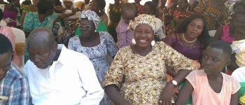 Eine Menschengruppe sitzt in Stuhlreihen da.