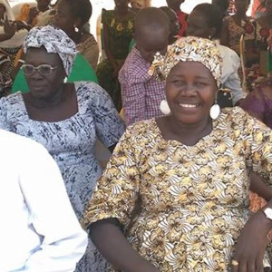 Eine Menschengruppe sitzt in Stuhlreihen da.