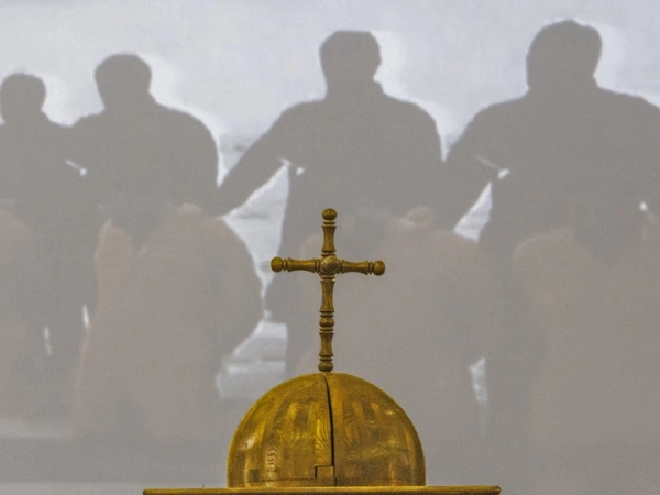 Ein Kreuz auf einer Kuppel. Im Hintergrund ist eine Christenverfolgung dargestellt.