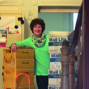 Doro lehnt an einem Stapel Postkisten.