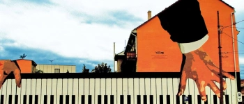 Auf ein Gebäude sind Hände gemalt, die Klavier spielen.