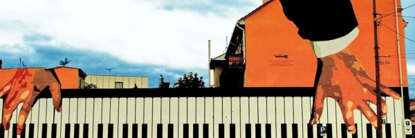 Auf ein Gebäude sind Hände gemalt, die Klavier spielen.