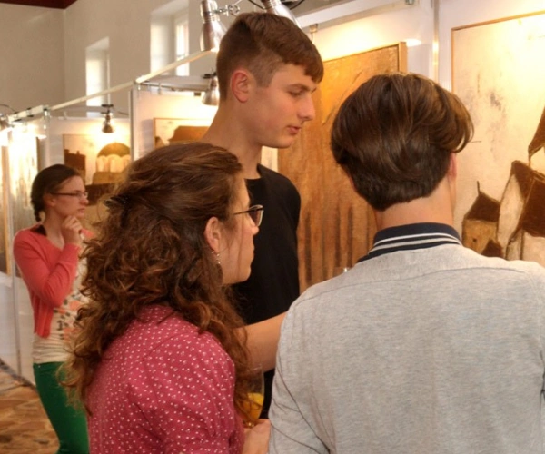 Junge Menschen in einem Museum betrachten ein Bild.