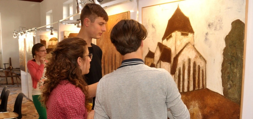 Junge Menschen in einem Museum betrachten ein Bild.