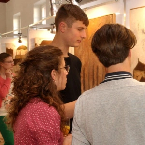 Junge Menschen in einem Museum betrachten ein Bild.