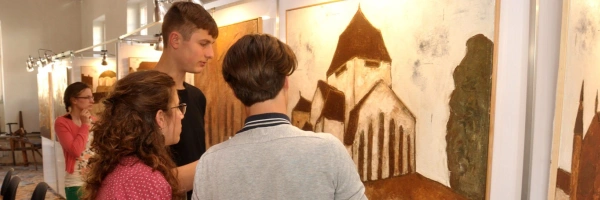 Junge Menschen in einem Museum betrachten ein Bild.