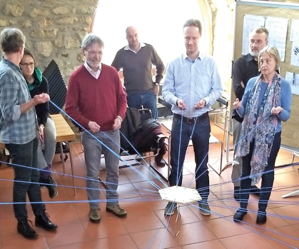An einem Strang ziehen. Mit der OJC unterwegs. Bild von OJClern beim Turmbauspiel.