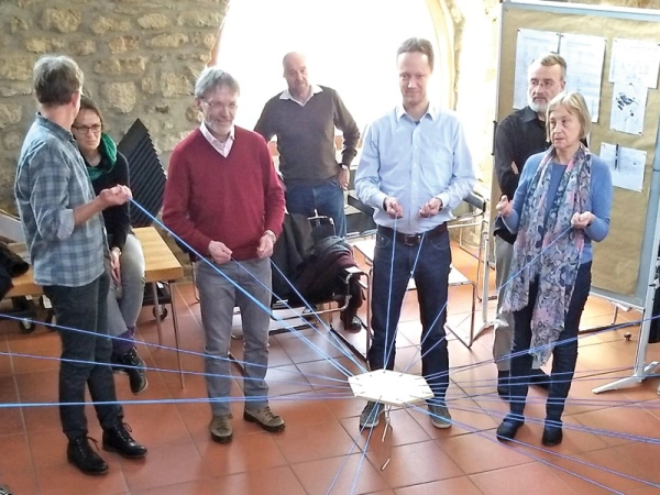 An einem Strang ziehen. Mit der OJC unterwegs. Bild von OJClern beim Turmbauspiel.