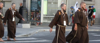 In kutten gekleidete Männer gehen über einen Zebrastreifen.