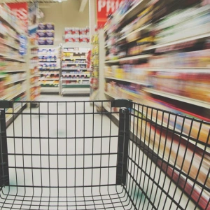 Ein Einkaufswagen in einem Supermarktgang.