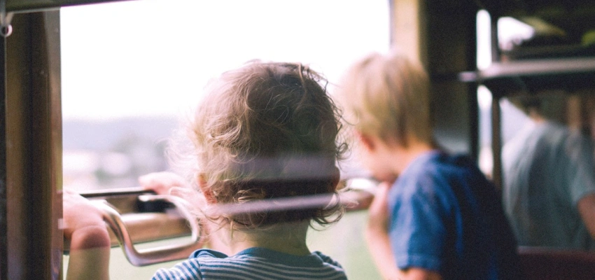 Kinder in einem Zug, die nach draußen schauen