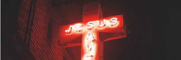Ein Kreuz aus Neonröhren mit Schriftzug 
