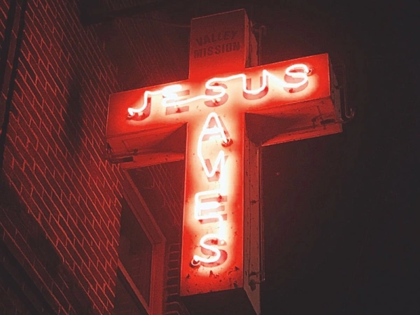 Ein Kreuz aus Neonröhren mit Schriftzug 