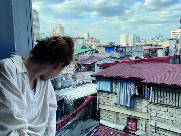Natalie schaut aus dem Fenster auf einen Slum von Manilla