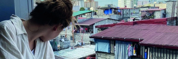 Natalie schaut aus dem Fenster auf einen Slum von Manilla