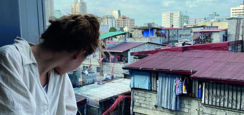 Natalie schaut aus dem Fenster auf einen Slum von Manilla