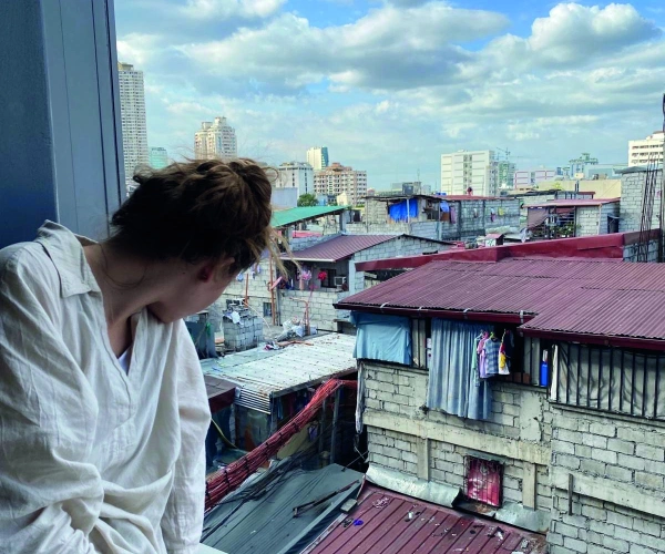 Natalie schaut aus dem Fenster auf einen Slum von Manilla