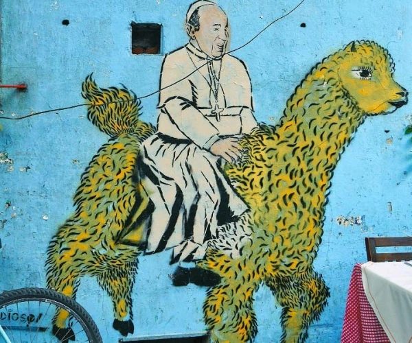 Buntes Gemälde eines Bischofs an einer blauen Hauswand