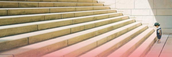 Kleines Kind am Ansatz einer großen Treppe