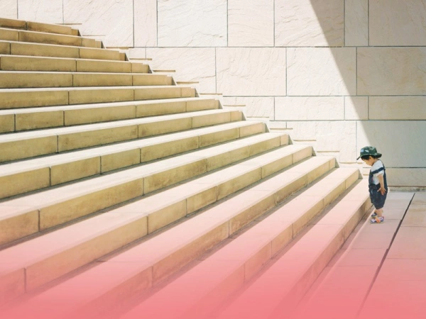 Kleines Kind am Ansatz einer großen Treppe