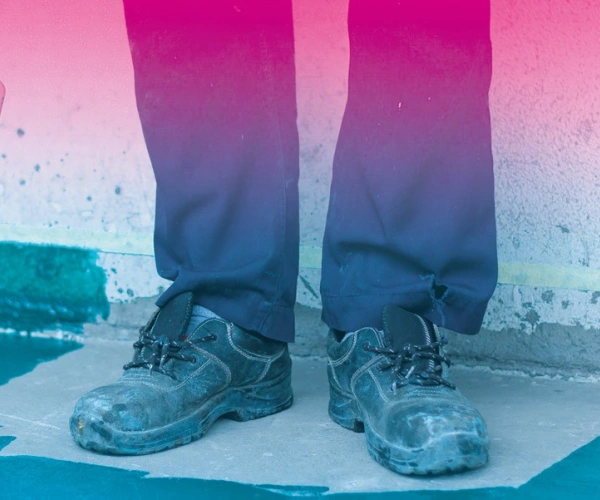 Schuhe eines Malers vor einer Wand