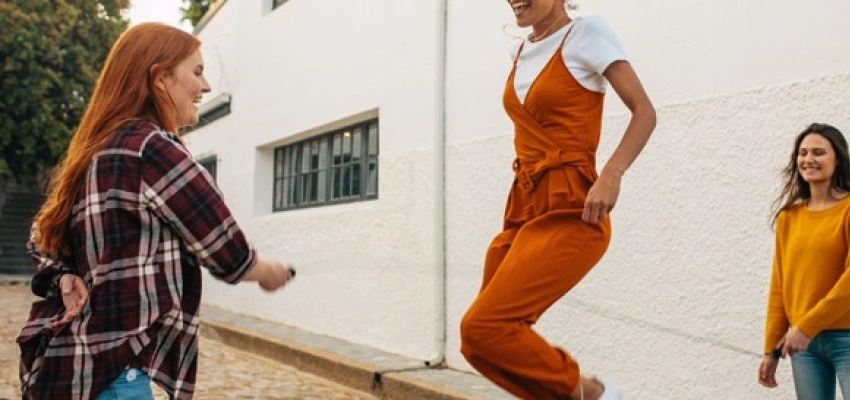 Drei lachende Personen beim Seilspringen