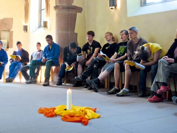 Menschen sitzen in einer Kapelle und singen