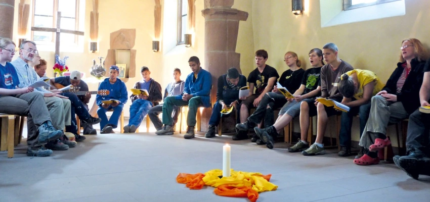 Menschen sitzen in einer Kapelle und singen