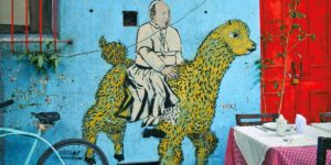 Mehr als erste Hilfe – Was den Samariter von den Frommen unterscheidet. Mural mit Papst Franziskus auf einem Lamm.